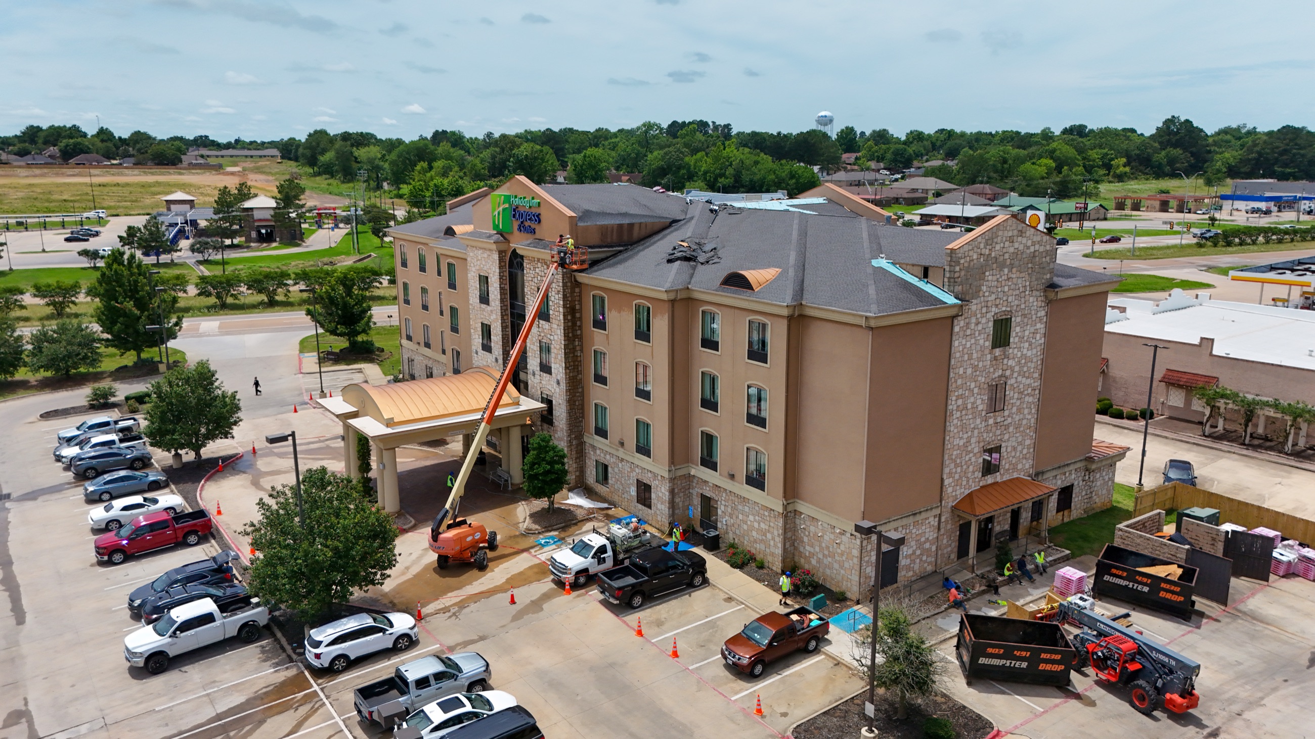 Aerial view of NETX Softwash boom lift extended to the roofline of a multi-story hotel