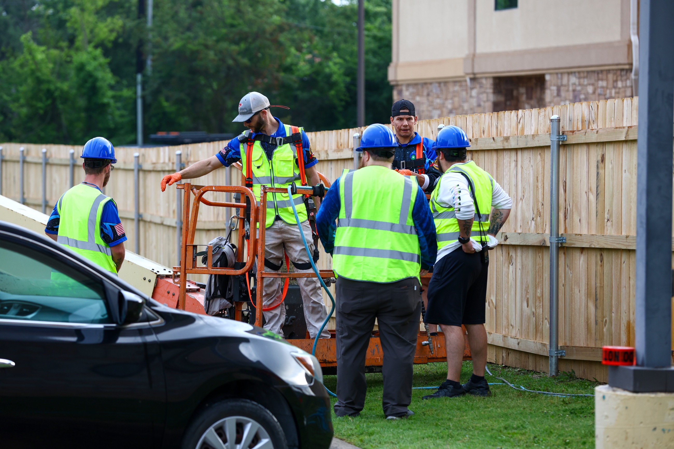 NETX Softwash crew in hard hats and safety vests during a job-site safety briefing at a hotel
