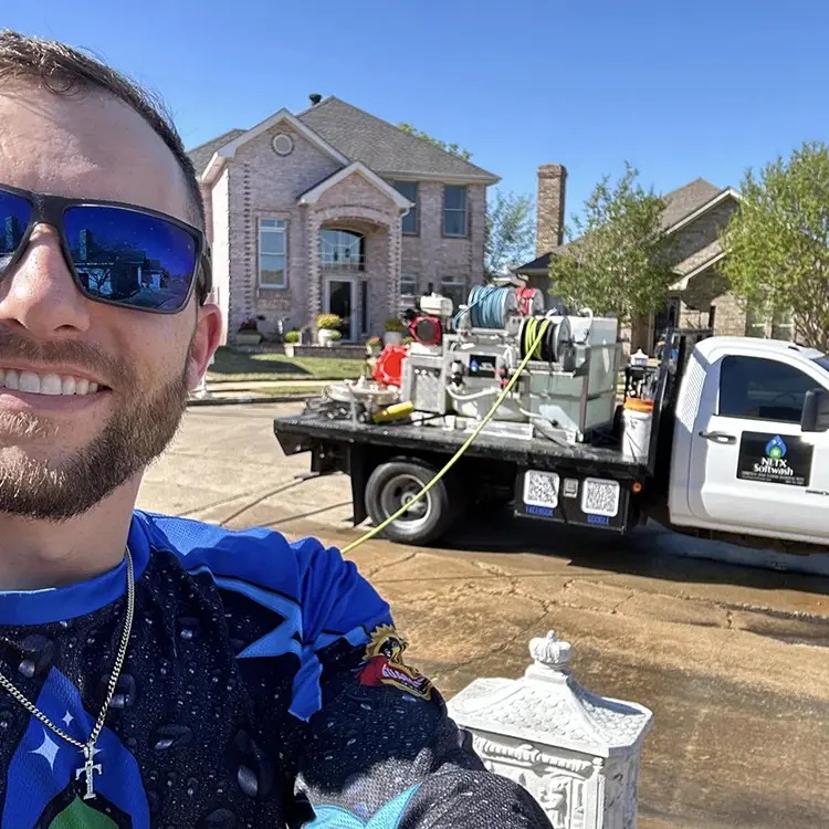 Trey, owner of NETX Softwash, standing with the softwash rig